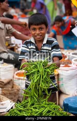 Porträt eines Jungen, der frische Chilis verkauft, Mapusa Friday Market, North Goa, Indien. Stockfoto