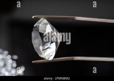 Luxuriöser Diamant in einer Pinzette auf schwarzem Hintergrund. Stockfoto