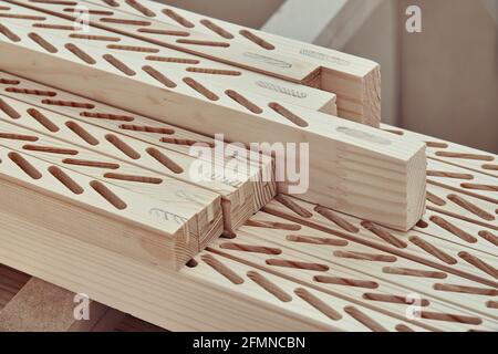 Neu bearbeitete Holzstäbe mit Linien von Schlitzen zu installieren Dünne Bretter liegen auf der Werkbank in der Nähe der leichten Schreinerei Stockfoto