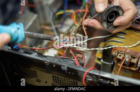 Man lötet Drähte während der Reparatur der Ausrüstung Stockfoto