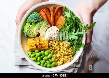 Vegane Frühstückschale - Rührtofu, Mais, Bohnen, Süßkartoffeln und Brokkoli. Stockfoto