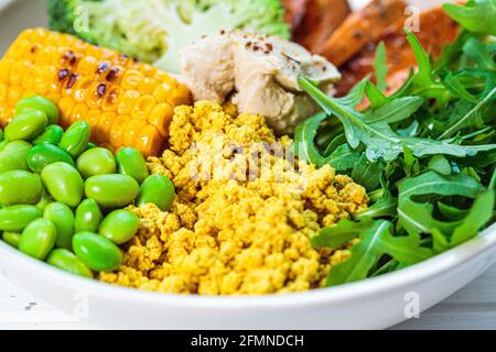 Vegane Frühstückschale - Rührtofu, Mais, Bohnen, Süßkartoffeln und Brokkoli. Stockfoto