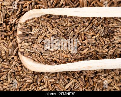 Draufsicht auf Holzschaufel auf Haufen Kümmel-Früchte Nahaufnahme Stockfoto
