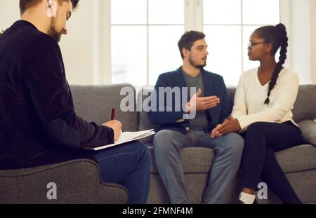 Familienberater schreibt Notizen, während das Paar über Beziehungsproblem spricht Stockfoto