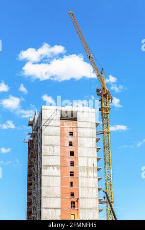 Große Wohnung Neubau im Bau mit Kran vor blauem Himmelshintergrund Stockfoto
