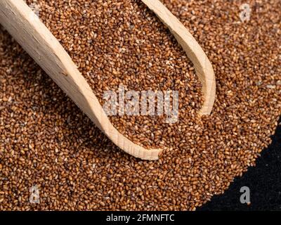 Holzlöffel auf Haufen von Vollkorntaufeln aus der Nähe Stockfoto