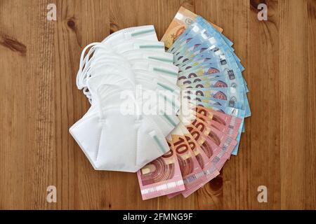 Krankenversicherung für die Kosten der Corona-Schutz Gesichtsmasken Bank Notizen Euro Holz launisch Konzept Stockfoto