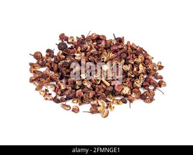Eine Handvoll getrockneter rosafarbener sichuanpfeffer in Nahaufnahme auf weißem Hintergrund Stockfoto