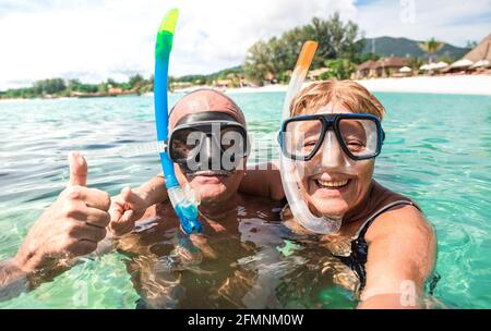 Senior glückliches Paar nimmt Selfie in tropischen Meer Ausflug mit Wasserkamera - Bootsfahrt Schnorcheln in exotischen Szenarien - Aktive ältere Menschen im Ruhestand Stockfoto