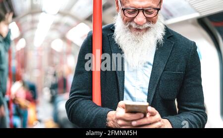 Hipster bärtiger Mann mit Handy in U-Bahn-Zug - trendige Erwachsene Person überprüfen Zeitplan mit Smartphone - glücklich Lifestyle und Technologie Stockfoto