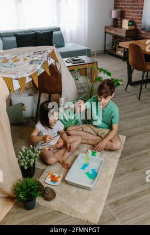 Kinder, die zu Hause campen und Angelspiele im Wohnzimmer spielen Zimmer Stockfoto