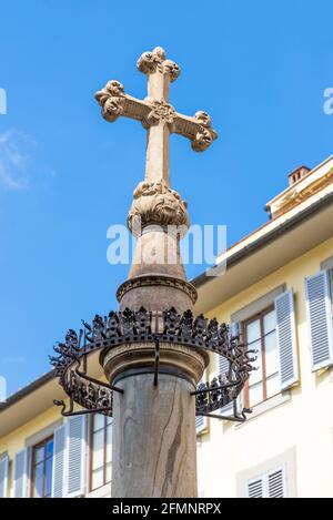 FLORENZ, ITALIEN - 24. Aug 2020: Florenz, Toskana/Italien - 24.08.2020: Ein Steinkreuz in der Mitte der Straße, das sehr alt und reich dekoriert ist. Stockfoto