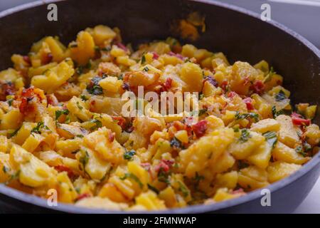 Gebratene Bratkartoffeln in einer Bratpfanne im Nahaufnahme-Hintergrund mit selektivem Fokus. Stockfoto