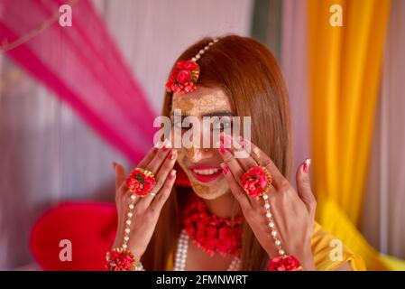 Porträt einer schönen indischen Braut mit Kurkuma haldi Paste auf ihrem Gesicht. Stockfoto