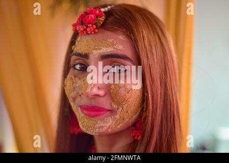 Porträt einer schönen indischen Braut mit Kurkuma haldi Paste auf ihrem Gesicht. Stockfoto