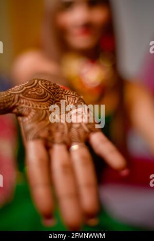 Nahaufnahme der Hände der atemberaubenden indischen Braut, Anwendung Hinna auf ihre Hochzeit. Stockfoto