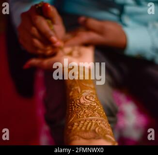 Nahaufnahme der Hände der atemberaubenden indischen Braut, Anwendung Hinna auf ihre Hochzeit. Stockfoto