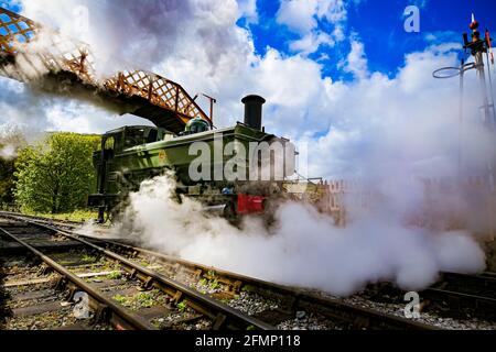 Great Western Pannier Tank 1336 Klasse No. 1369, gebaut 1933, angetrieben von Andy Letts, wird mit voller Kraft in den Bahnhof der dampfbetriebenen South Devon Railway (SDR) in Buckfastleigh, South Devon, wo Mitarbeiter, Fahrer und Ingenieure überprüfen die Ausrüstung, während sie die Attraktion vorbereiten, um sich für die Wiedereröffnung für die Öffentlichkeit am Montag, den 17. Mai vorzubereiten, bevor die Sperrbeschränkungen in England weiter gelockert werden. Bilddatum: Dienstag, 11. Mai 2021. Stockfoto