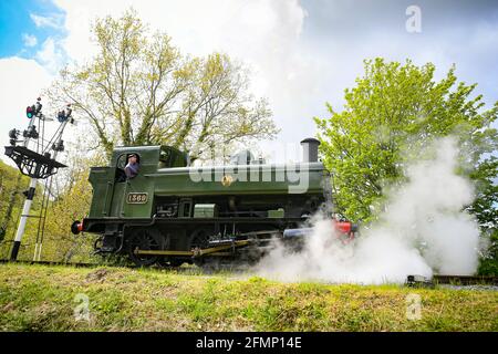 Great Western Pannier Tank 1336 Klasse No. 1369, gebaut 1933, angetrieben von Andy Letts, wird mit voller Kraft in den Bahnhof der dampfbetriebenen South Devon Railway (SDR) in Buckfastleigh, South Devon, wo Mitarbeiter, Fahrer und Ingenieure überprüfen die Ausrüstung, während sie die Attraktion vorbereiten, um sich für die Wiedereröffnung für die Öffentlichkeit am Montag, den 17. Mai vorzubereiten, bevor die Sperrbeschränkungen in England weiter gelockert werden. Bilddatum: Dienstag, 11. Mai 2021. Stockfoto
