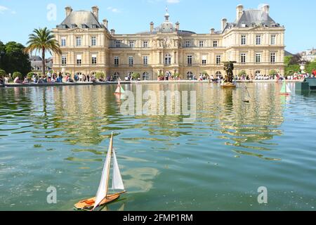 Ein Blick auf den Palais du Luxembourg und den Senat im Jardin du Luxembourg in Paris mit einem Spielzeug-Segelboot im Vordergrund an einem sonnigen Sommertag. Stockfoto