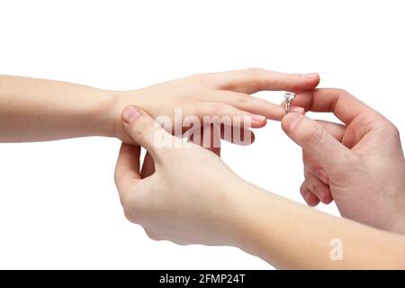 Hände auf weißem Hintergrund. Ein Mann legt einen Ring auf den Finger einer Frau. Ring mit Stein Stockfoto