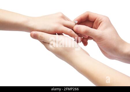 Hände auf weißem Hintergrund. Ein Mann legt einen Ring auf den Finger einer Frau. Ring mit Stein Stockfoto