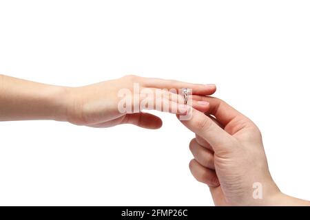 Hände auf weißem Hintergrund. Ein Mann legt einen Ring auf den Finger einer Frau. Ring mit Stein Stockfoto