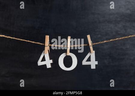 Zahlen 404 mit Wäscheklammern auf schwarzem Hintergrund. Fehler 404. Etwas stimmt nicht. Inschrift aus weißen Zahlen Stockfoto