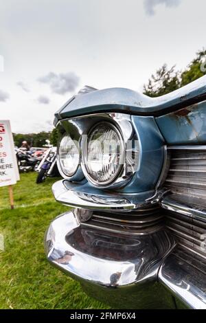 Nahaufnahme des vorderen Stoßfängers des Vintage Cadillac Coupé de Ville mit Chromdetails, die klassische runde Scheinwerfer auf einer Outdoor-Automobilausstellung zeigen Stockfoto