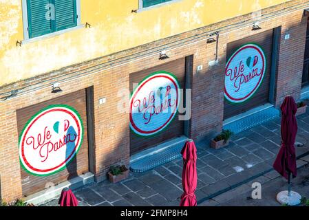 PISA, ITALIEN - 22. Aug 2020: Ein kleines geschlossenes Restaurant mit geschlossenen Fensterläden, auf dem geschrieben steht: "We love Pasta" mit geschlossenen Sonnenschirmen auf der Straße Stockfoto