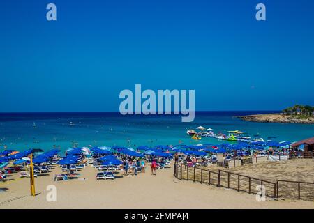 Fantastischer Protaras Strand (Feigenbaumbucht) neben Protaras im august - mediterraner Ferienort! Nicht erkennbare Personen. Eine Person Paragliding - kleine p Stockfoto