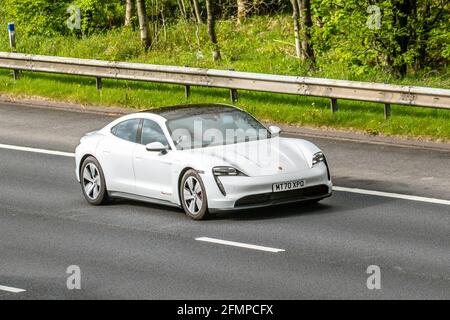 2020 weißer Porsche Taycan 4s 93KWH Sportwagen; Fahrzeugverkehr, bewegliche Fahrzeuge, Autos, Fahrzeug auf britischen Straßen, Motoren, Fahren auf der Autobahn M6, britisches Straßennetz. Stockfoto