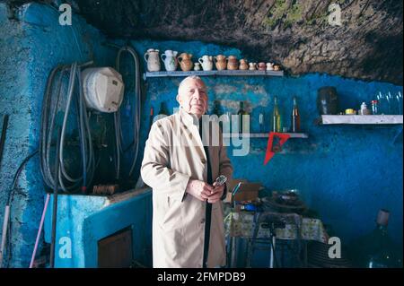 Porträt eines Weinherstellers in einem der antiken Fässer, die in den Berg gegraben wurden. Hier wird der Wein für Tausende von Jahren aufbewahrt. In diesem Schurken Stockfoto