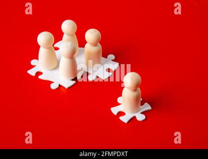 Holzfiguren auf Puzzles auf rotem Hintergrund als Symbol für Teambildung. Organisationsgruppe Mitarbeiter im Geschäft. Zusammenarbeit und Partnerschaft. Stockfoto