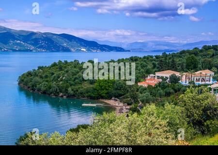 Korfu Insel/Griechenland - 8. Mai 2019: Wunderschöne Sommerlandschaft mit Badeort -türkisfarbenes ruhiges Wasser, Berge, Hotel mit Pool auf dem Hügel und Stockfoto