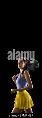Junge kaukasische Frau spielt Tennis isoliert auf schwarzem Studio Hintergrund in Aktion und Bewegung, Sport-Konzept Stockfoto