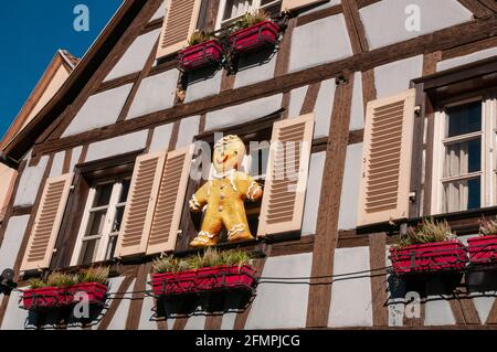 Fassade eines Hauses mit einem hängenden Lebkuchenmann im malerischen Dorf Kaysersberg, elsässische Weinstraße, Haut-Rhin (68), Region Grand Est, Franc Stockfoto