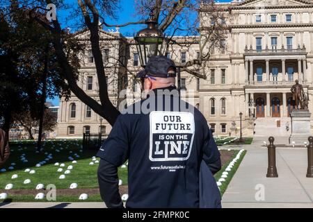 Lansing, Michigan, USA. Mai 2021. Die Mitglieder der Gewerkschaft der United Steelworkers legen harte Hüte auf den Rasen der Staatshauptstadt, um die Arbeitsplätze zu repräsentieren, die nach ihrer Meinung durch die Schließung der Enbridge Line 5, einer Ölpipeline, die unter der Straße von Mackinac verläuft, verloren gehen würden. Aus Angst, dass ein Leck eine katastrophale Verschmutzung der Großen Seen verursachen könnte, hat der Gouverneur von Michigan, Gretchen Whitmer, Enbridge angewiesen, die Pipeline zu schließen. Das Unternehmen sagt, dass es dieser Anordnung trotzen wird. Kredit: Jim West/Alamy Live Nachrichten Stockfoto