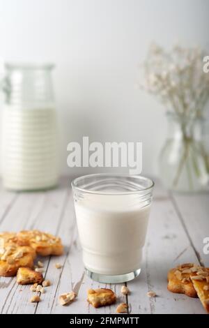 Milch mit frisch gebackenen hausgemachten Plätzchen mit Erdnüssen auf einem Heller Hintergrund Stockfoto