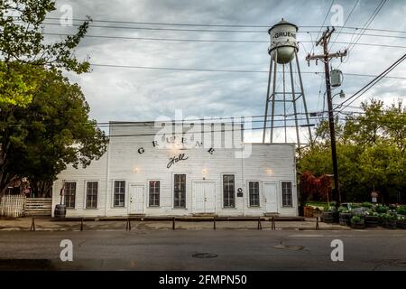 GRUENE, TEXAS - MÄRZ 28 2021: Die Gruene Hall ist die älteste, kontinuierlich in Betrieb befindliche Tanzhalle in Texas, die 1878 mit einem Wasserturm im Hintergrund erbaut wurde Stockfoto