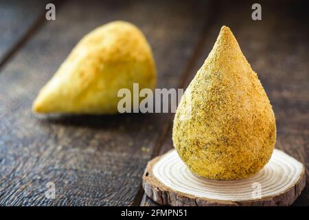 Brasilianische Vorspeise, gebratene Hühnercroquette, genannt Chicken Coxinha, typisch brasilianisches Baressen Stockfoto