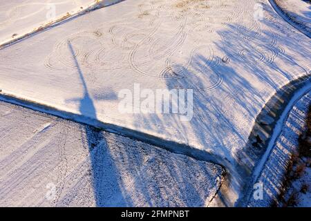Schatten von Mühle und Bäumen im Schnee Stockfoto