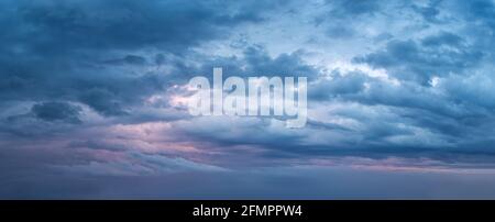 Dramatischer Himmel am Abend Panoramaaufnahme. Landschaftlich schöne blaugraue Wolken vor dem Sturm. Wolkenlandschaft vor dem Regen. Blaue Stunde stürmische Wolkenlandschaft. Stockfoto