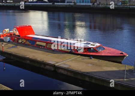 DUBLIN, IRLAND - 28. Oktober 2019: Rotes, glasüberdachtes Ausflugsboot, das auf dem Fluss Liffey andockt und auf Touristen wartet. Das Boot mit dem Namen „Spirit of Docklands“ Oper Stockfoto