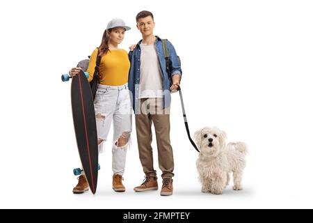 Skater Mädchen und ein Kerl mit einem maltesischen Pudel Hund Isoliert auf weißem Hintergrund Stockfoto