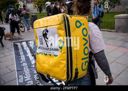 Ein Glovo-Händler vor der Puerta de Moncloa, der während der Demonstration ein Banner vorbereitet.Dutzende von "Reitern" (Lebensmittelhändler) demonstrieren und behaupten, ihre Arbeit als Freiberufler und gegen die Bedingungen von Lieferfirmen wie Globo und Deliveroo zu leisten. Heute Morgen verabschiedete Spanien das "Riders Law" und gab Unternehmen eine Frist von 3 Monaten, um Leute einzustellen, anstatt sie als falsche Freiberufler zu haben. Die Ministerin für Arbeit und Sozialwirtschaft, Yolanda Díaz, wies darauf hin, dass Spanien das erste Land sein wird, das einen Standard für digitale Plattformen hat. (Foto von Diego Radames/SOPA Images/SIP Stockfoto