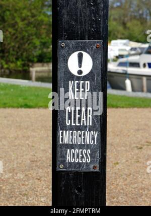 Ein Keep Clear Emergency Access Schild von Malthouse Broad auf den Norfolk Broads in Ranworth, Norfolk, England, Vereinigtes Königreich. Stockfoto