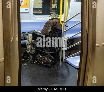 Ein Obdachloser im Rollstuhl schläft am Samstag, 8. Mai 2021, in einem E-Zug in der U-Bahn in New York inmitten seines Mülls. (© Richard B. Levine) Stockfoto