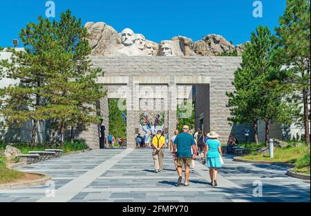 Touristen, die am Eingang des Mount Rushmore nationalen Denkmals mit den US-Präsidenten geschnitzten Gesichtern, South Dakota, USA, spazieren. Stockfoto