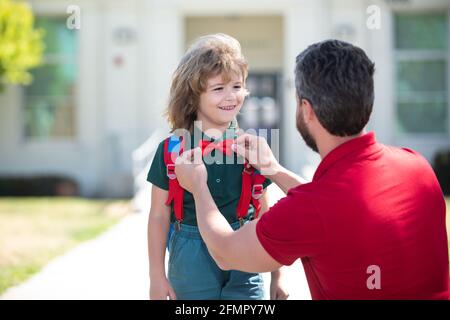 Vater sagt Auf Wiedersehen seinem kleinen Sohn in der Nähe der Schule. Kindererziehung. Erster Schultag. Stockfoto
